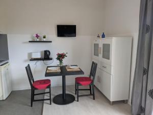 a kitchen with a table with two chairs and a refrigerator at Virginia N101 ST2 in Grasse