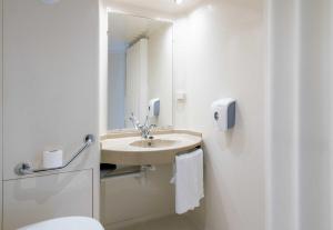a bathroom with a sink and a toilet and a mirror at B&B HOTEL Bayeux in Bayeux +36 photos