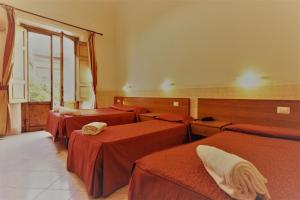 a room with four beds and a window at Hotel Palazzuolo in Florence