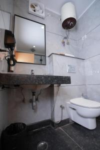 a bathroom with a sink and a toilet and a mirror at Annekaa Heights in Vrindāvan +49 photos