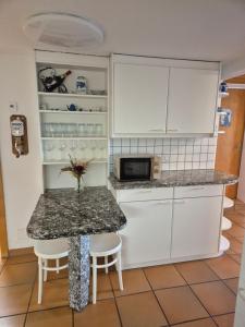 a kitchen with white cabinets and a table with chairs at Nenis Hüsli in Diesbach