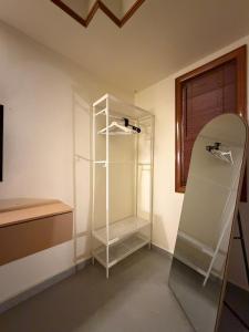 a white closet with a glass shelf in a room at Brassalova Signature Stay in Port Dickson