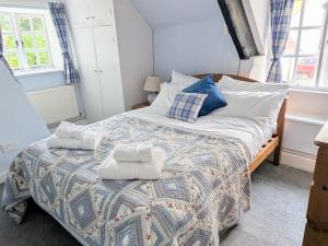 a bedroom with a bed with towels on it at Plush Cottage in Dorchester