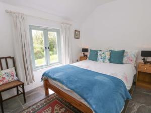 a bedroom with a bed and a window at Rhos Y Clegyrn in Goodwick