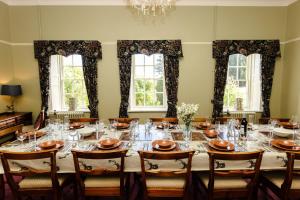 a large dining room with a long table with chairs at Cheviot Manor in Wooler