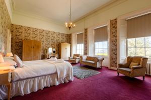 a bedroom with a large bed and two chairs at Cheviot Manor in Wooler +98 photos