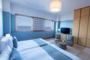 a bedroom with a large bed and a television at Hayama Umino Hotel in Hayama