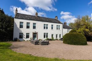 a large white house with a large yard at Cheviot Manor in Wooler