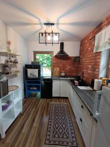a kitchen with white cabinets and a brick wall at Dom całoroczny Leśny Czar balia, sauna na 12 osób in Raków