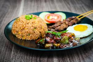 a plate of food with rice and meat and eggs at Ambiance in Zierikzee