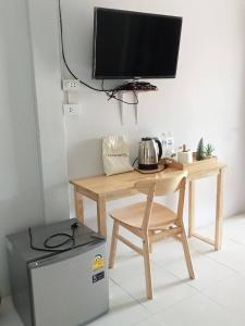 a desk with a television and a chair and a microwave at บ้านอยู่สบาย บึงโขงหลง in Ban Don Klang