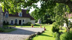 a house with a gravel driveway in front of it at Maison d'Hôtes Les Après in Bellême