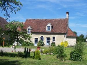 uma casa de tijolos brancos com um telhado vermelho em Maison d'Hôtes Les Après em Bellême