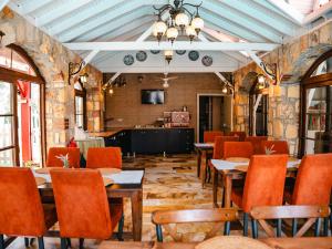 a dining room with tables and chairs and a tv at Melrose Pansiyon in Pamukkale