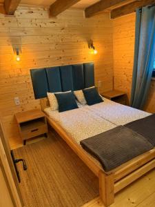 a bedroom with a bed in a wooden cabin at Domek z jacuzzi Wypoczynek Pod Lipami in Wólka