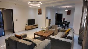 ein Wohnzimmer mit zwei Sofas und einem Tisch in der Unterkunft Résidence EBENZ in Jaunde + 13 Fotos