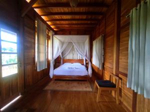 a bedroom with a bed in a wooden house at 361 Alam in Tetebatu