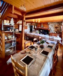 a dining room with a long table and chairs at Solayan Nature & Spa, Piscine Intérieure, Bains Nordiques & Vue Pyrénées in Couledoux