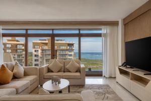 a living room with a couch and a large window at Tulip Residences Vipingo Mombasa in Mombasa
