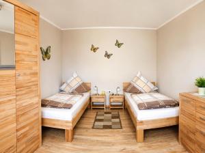 two beds in a room with butterflies on the wall at Ferienwohnungen Stark in Kelheim