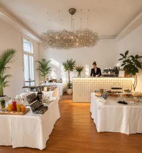 a room with tables with food and a person in the background at Palazzo Otello 1847 Wellness & Spa in Vicenza