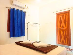a bedroom with a bed with a blue curtain at The Blue Planet Long Island in Middle Andaman