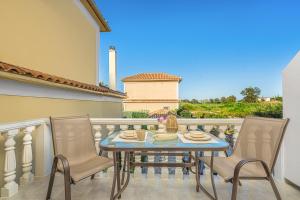 a table and chairs on a balcony with a view at Villa Dionysios in Keri