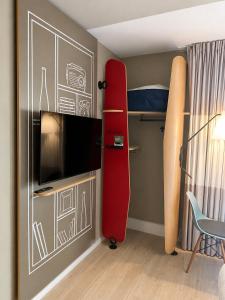 a bedroom with a red bunk bed and a surfboard at Hotel ibis Dijon Centre Clemenceau in Dijon