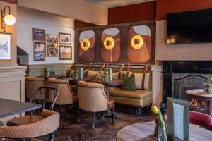 a restaurant with tables and chairs and a fireplace at Royal Oak at Keswick in Keswick