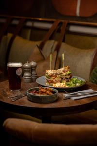 a table with a sandwich and salad and a drink at Royal Oak at Keswick in Keswick