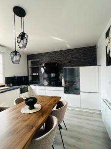 a kitchen with a wooden table and some chairs at Downtown High Standing Duplex - "CENTRUM" in Épernay