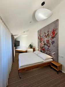 a bedroom with a bed and a painting on the wall at Hotel U Feldů in Klimkovice