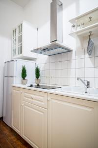 a white kitchen with a sink and a refrigerator at Seaside house in Liepāja