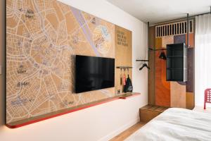 a flat screen tv on a wall in a bedroom at Hotel Schani Naschmarkt - opening September 2026 in Vienna