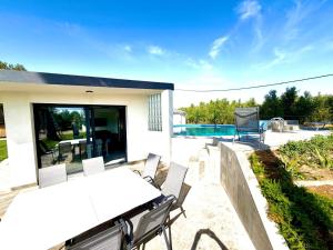 a patio with a table and chairs and a pool at Villa Escaldes in Montroig