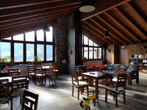 a dining room with tables and chairs and windows at Camping Can Fosses in Planoles