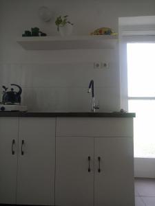 a kitchen with white cabinets and a sink at Peace House in Esztergom