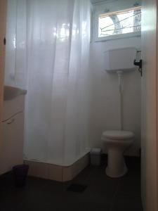 a white bathroom with a toilet and a window at Peace House in Esztergom