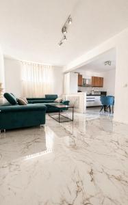 a living room with marble floors and green couches at Centrium Makarska in Makarska
