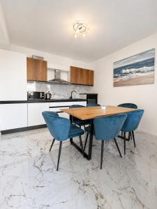 a kitchen with a wooden table and blue chairs at Centrium Makarska in Makarska