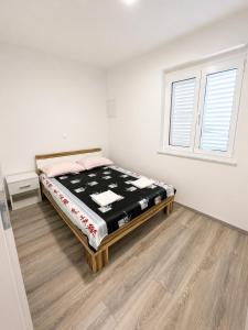 a bedroom with a bed in a room with a window at Centrium Makarska in Makarska +2 photos