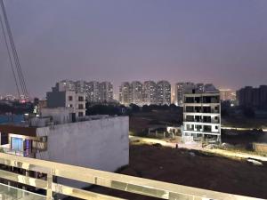a view of a city at night with tall buildings at Blooming Inn in Gurgaon +8 photos