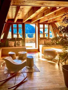 a living room with a chair and tables and windows at Solayan Nature & Spa, Piscine Intérieure, Bains Nordiques & Vue Pyrénées in Couledoux +34 photos
