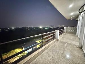 a balcony with a view of a city at night at Blooming Inn in Gurgaon