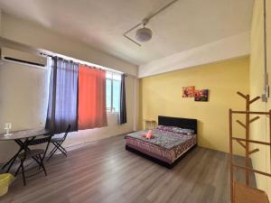 a room with a bed and a table and a desk at WAQI Homestay in Miri