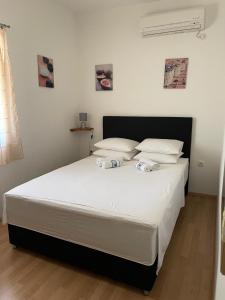a bedroom with a large bed with white sheets and pillows at Apartment Sajković in Ugljan