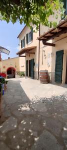 a building with green doors next to a street at B&B Casa Fattorini in Cortona