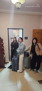 a group of people standing in a room with luggage at Corps Rose Velley in Almaty