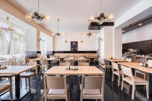 a dining room with wooden tables and chairs at EA Hotel Lipno in Černá v Pošumaví