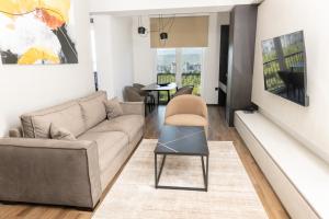 a living room with a couch and a chair at Hotel Cube 55 - Business Suites in Skopje +9 photos